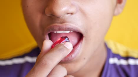 close-up of a child taking a pill