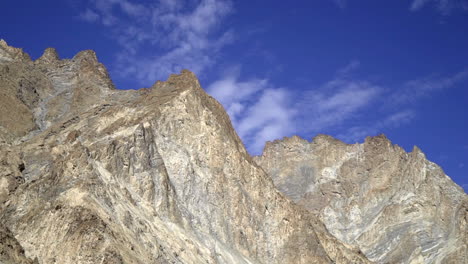 bald mountain tops, peaks against the clear blue sky, pan right shot