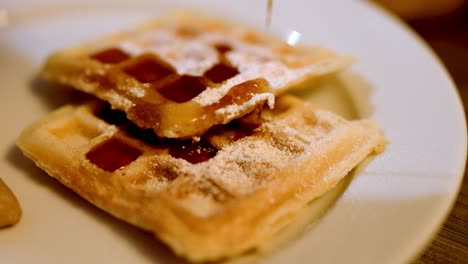 deliciosos gofres con jarabe de arce que se vierte, plato de desayuno