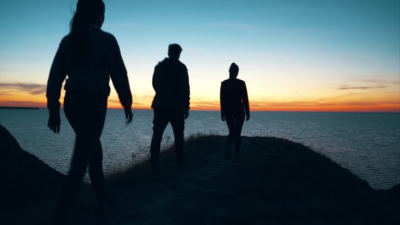 세 사람이 바다 풍경에 맞춰 산을 고 있습니다.