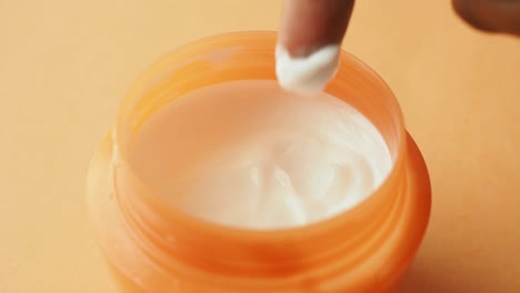 applicare la crema da un barattolo d'arancia