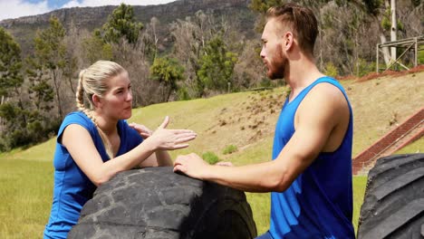 Fit-man-and-woman-interacting-with-each-other-during-obstacle-course