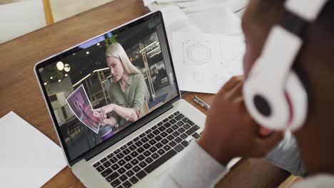 estudiante universitario afroamericano que usa auriculares haciendo una videollamada en una computadora portátil en casa