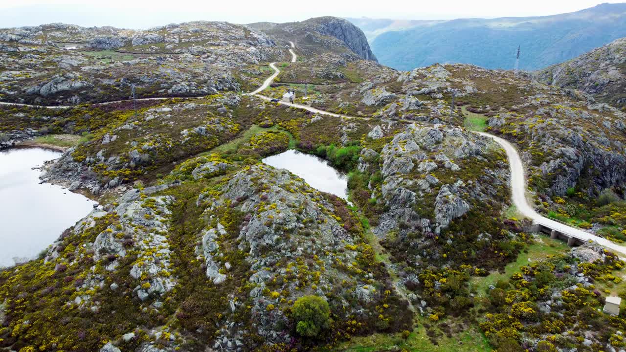 panorámica aérea de ángulo ancho de los lagos de montaña de sierra segundera por carretera de campo