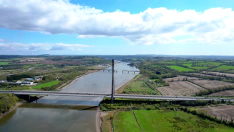 drone landscape establishing shot traffic crossing the thomas francis meagher bridge outside waterford city impressive structure and bypassing waterford city