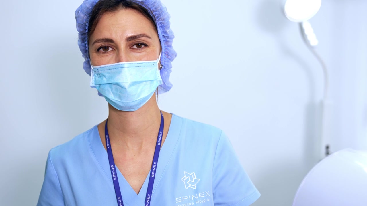 Médico de laboratório abre o equipamento de esterilização. O médico usa pinças longas para pegar instrumentos esterilizados.