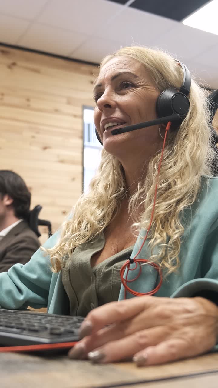 Telefonselger snakker med kunder på headset. Vertikale filmopptak