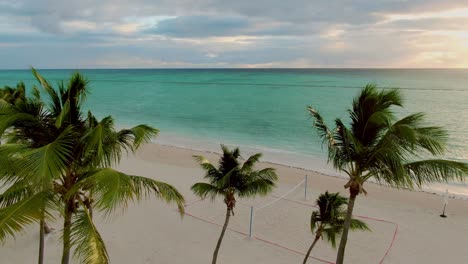 Tropical-lagoon-at-sunset,-sunrise,-paradise-scene-with-palm-trees-and-crystal-clear-turquoise-color-ocean,-vacation-and-holiday-scene