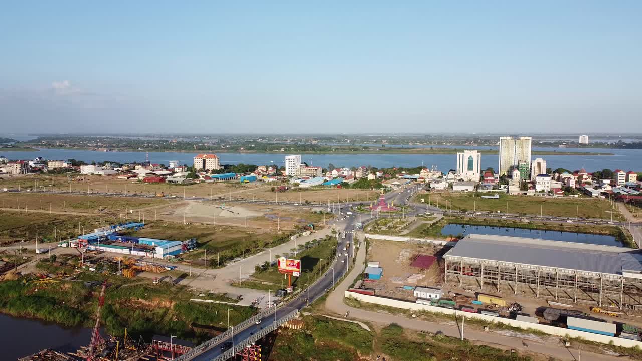 toma panorámica estática aérea del tráfico en la carretera y el río mekong en segundo plano en un día soleado, camboya
