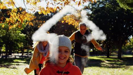 smoke forming a house shape against caucasian family playing in the park