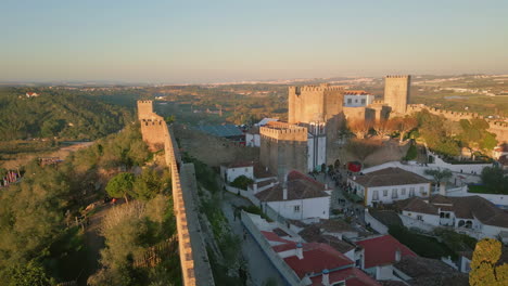 drone stone fortification walls in medieval village at sunset. ancient fortress