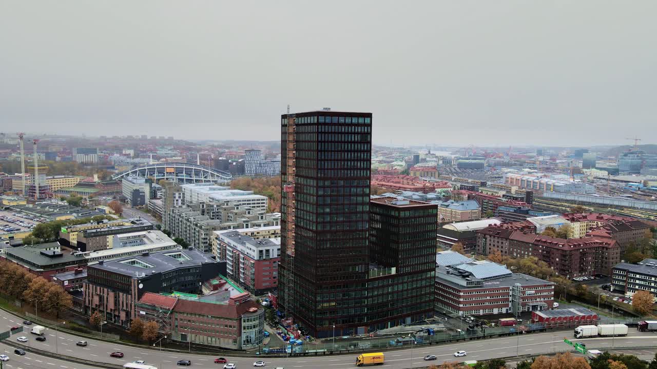 Traffic At European Route E6 In Gothenburg, Sweden With View Of New Building Under Construction On A Dramatic Day. aerial drone, panning left