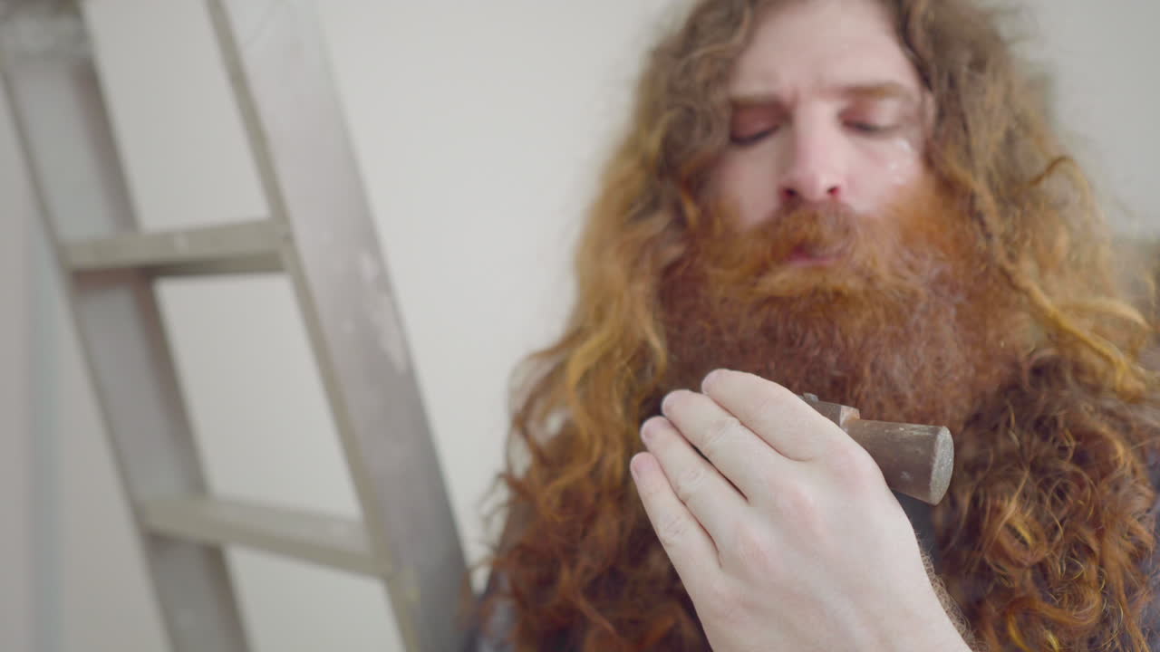 hombre de reparación de viviendas inspeccionando un viejo martillo antiguo que parece necesitar un foco de fijación