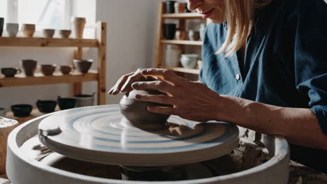 close-up of hands shaping clay on a potter's wheel