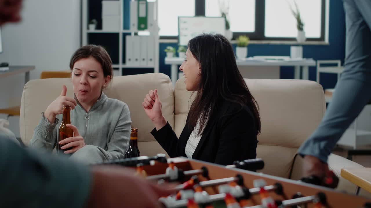 Cheerful women talking while holding bottles of beer