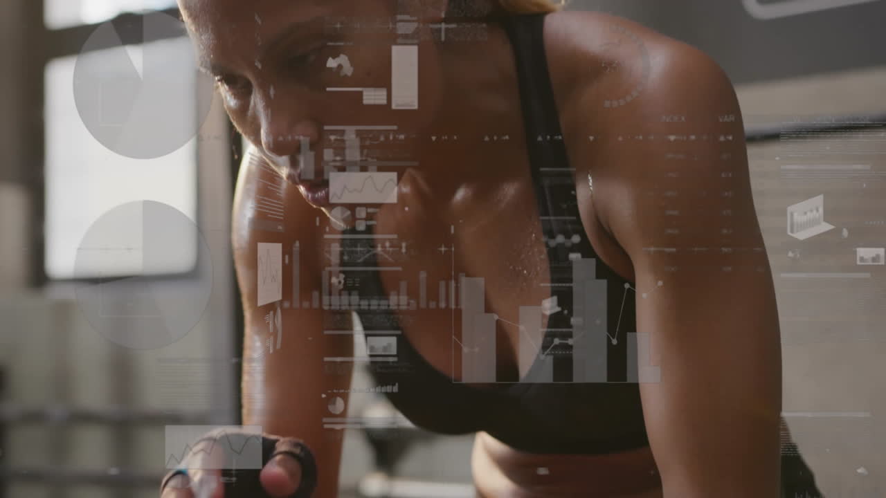 Mid adult woman wiping sweat in gym fitness session, with biometric data charts floating overhead