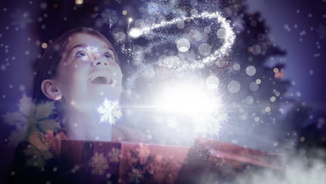 chica emocionada abriendo la caja de regalos de navidad mágica con luz brillante