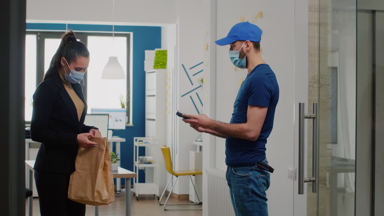 코로나바이러스에 대한 보호 의료 얼굴 마스크와 장갑을 착용한 배달 직원이 식사 점심을 가져오고 있습니다.