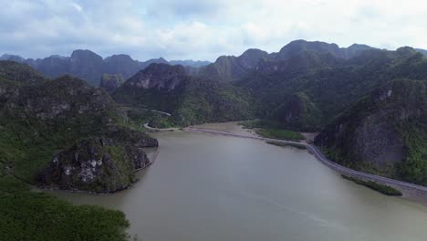 zoom in above calm waters and rocky terrain under bright sky