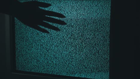 female hand touching an old tv screen with ripples