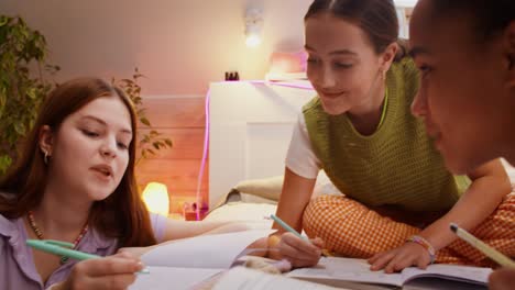 teenage friends studying in bedroom