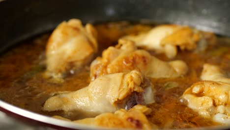 cooking chicken curry in a pan