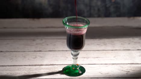 Nahtloser,-Sich-Wiederholender-Clip-Von-Rotwein,-Der-In-Ein-Rustikales-Glas-Mit-Blauem-Hintergrund-Gegossen-Wird