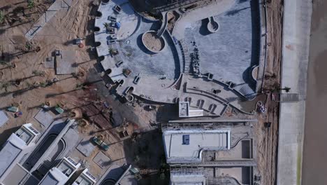 beach resort or residential development under construction from top down aerial view including villas and swimming pool on a sunny day