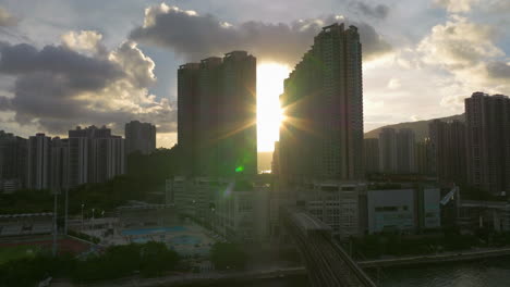 sun flares between high-rise buildings tsing yi, hong kong,asia