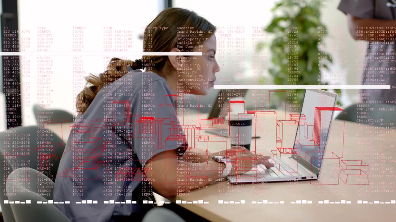 Clinica che digita sul laptop, attivando una sovrapposizione di codice mentre controlla i dati, con un collega che si avvicina.