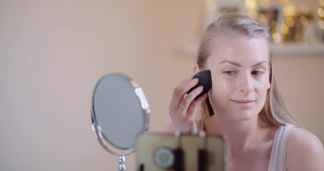 Mujer-Joven-Haciendo-Maquillaje-Delante-Del-Espejo-En-Casa