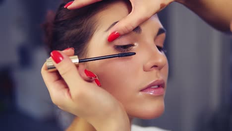 Maquillador-Profesional-Aplicando-Rímel-En-El-Ojo-De-La-Modelo.-Trabajar-En-La-Industria-De-La-Moda-De-Belleza.-Maquillaje-Profesional-Detrás-Del-Escenario