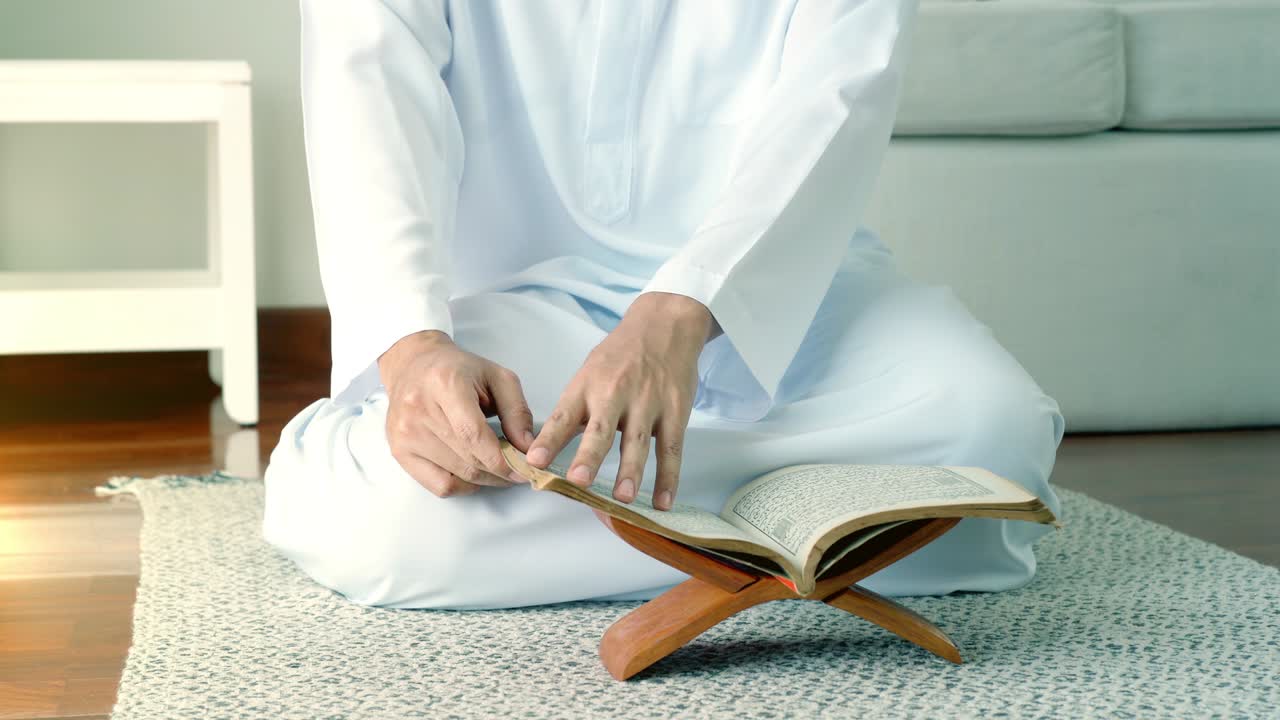 아시아의 무슬림 남자가 집에서 기도하고 드리고 있습니다.