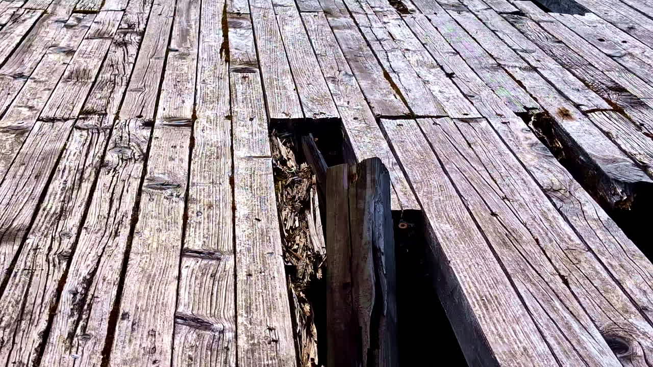 Weathered wooden planks with broken and warped boards on old surface structure