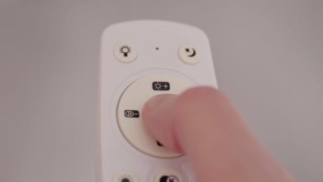 remote controller of light. a male hand holds a remote controller and switches lighting modes. pressing buttons, bad signal transmission