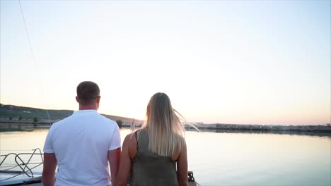 couple watching sunrise from a boat dock