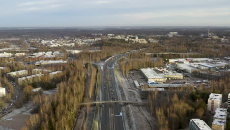 aerial, rising, drone shot overlooking traffic on the highway vihdintie 120, on a sunny, autumn evening, in pitajanmaki, helsinki, uusimaa, finland