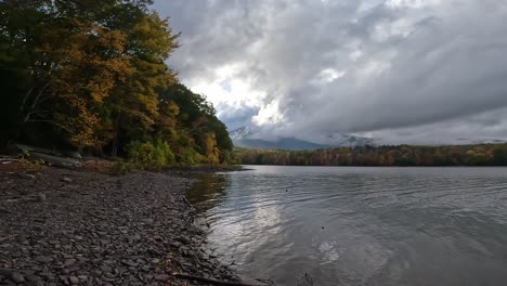 Beautiful-rocky-lakeshore-during-peak-foliage-on-a-stormy-day---slow-motion