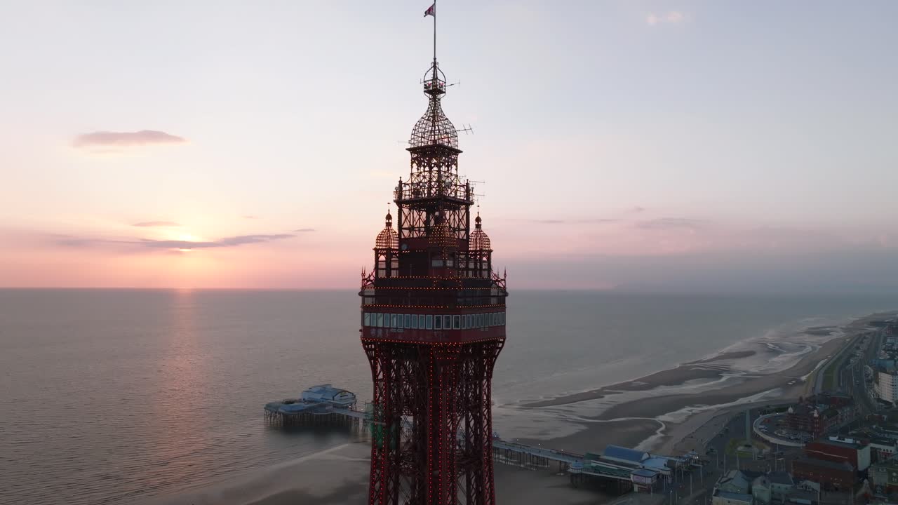 Blackpool Tower pull away shot from observation deck level with North Pier behind, at sunset. Lancashire, UK.