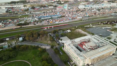 Antena-De-Un-Tren-Que-Pasa-Entre-La-Facultad-De-Derecho-Y-La-Villa-31-En-Buenos-Aires,-Argentina