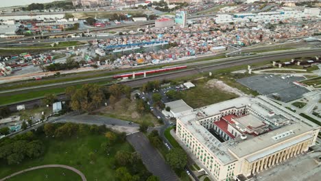 aérea de un tren que pasa entre la facultad de derecho y la villa 31 en buenos aires, argentina.
