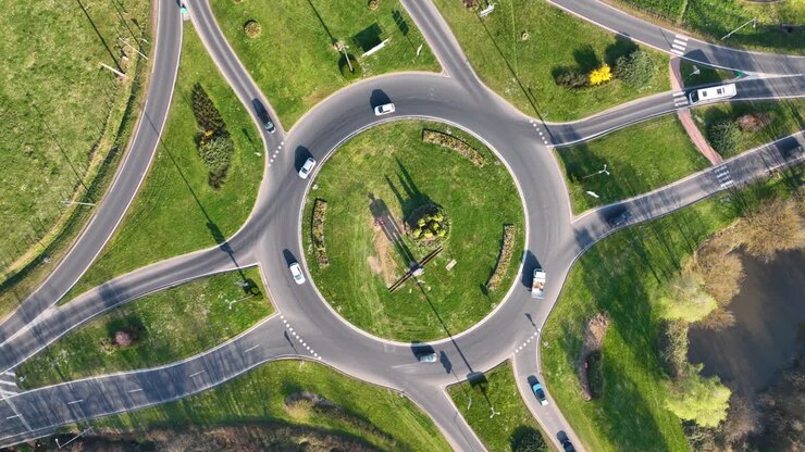 Aerial view of road roundabout intersection with fast moving heavy traffic. Urban circular transportation crossroads
