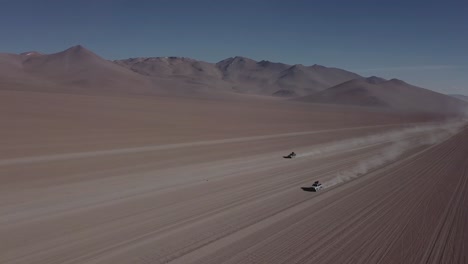 Two vehicles driving parallel through the Salvador Dal&iacute; Desert in Bolivia