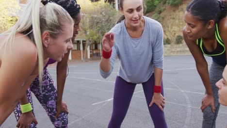 diverse female basketball team discussing game tactics and teaming up