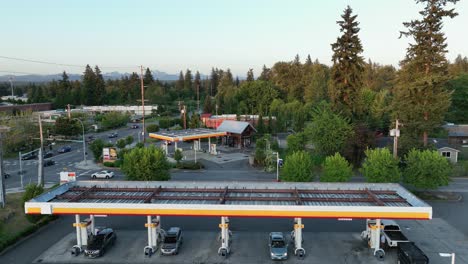 Drone-shot-flying-over-a-full-gas-station-during-the-evening