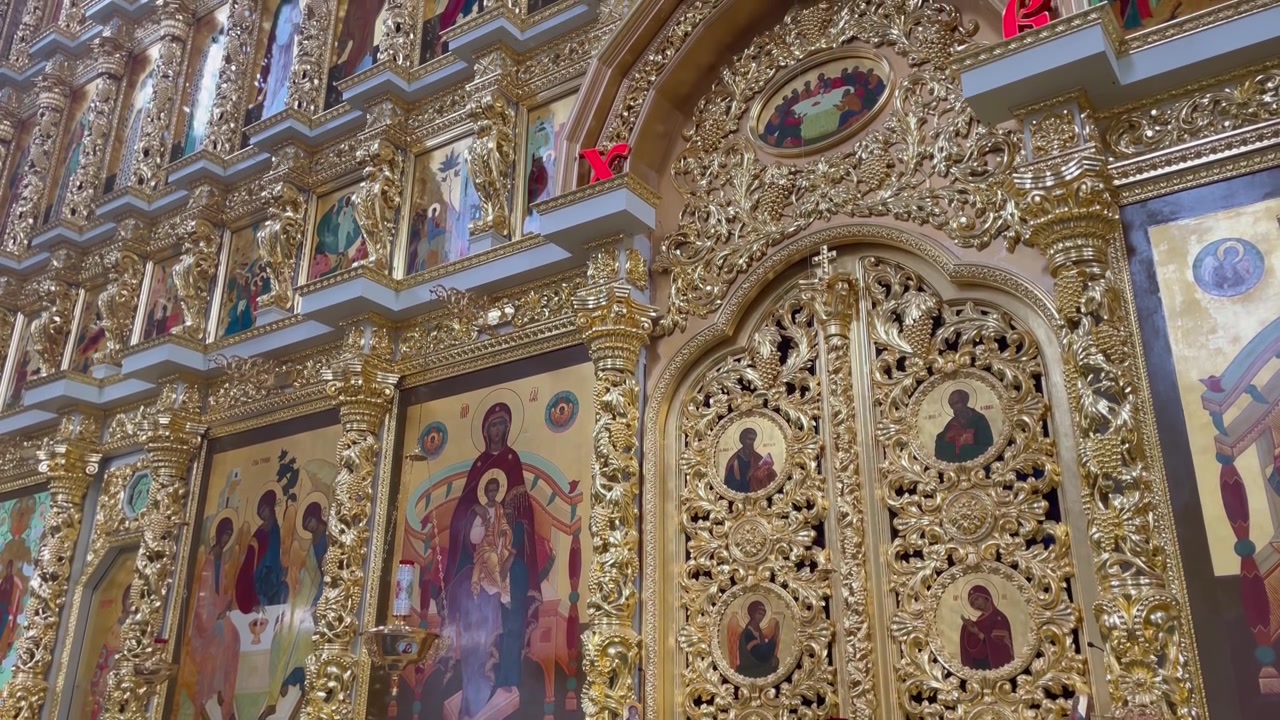 Nahaufnahme der goldenen Ikonostase und der Königlichen Türen in der Mariä-Himmelfahrt-Kathedrale, Astrachaner Kreml, Russland. Mit aufwendigen Schnitzereien und traditionellen orthodoxen religiösen Ikonen