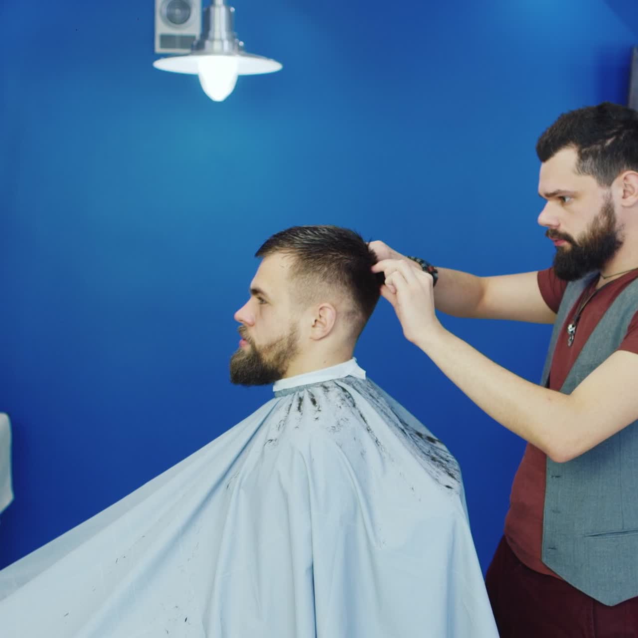 peluquero cortando el cabello para el cliente en una barbería 01