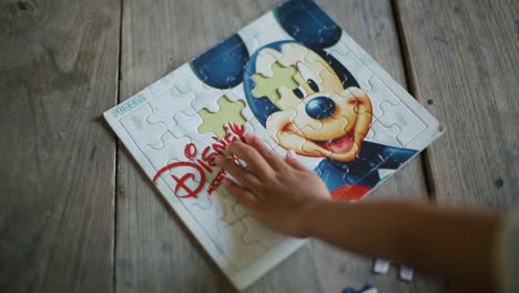 hands of a autistic child arranging color puzzle symbol of awareness for autism spectrum disorder