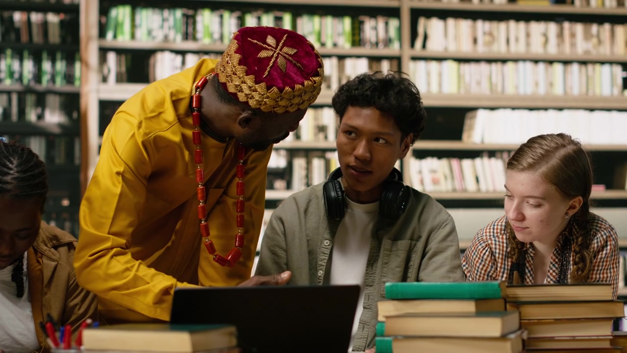 Studenti e tutor che lavorano insieme con un laptop e condividono idee.