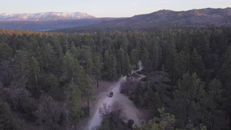 4wd vehicle on dirt track country road to remote forest campsite, aerial view